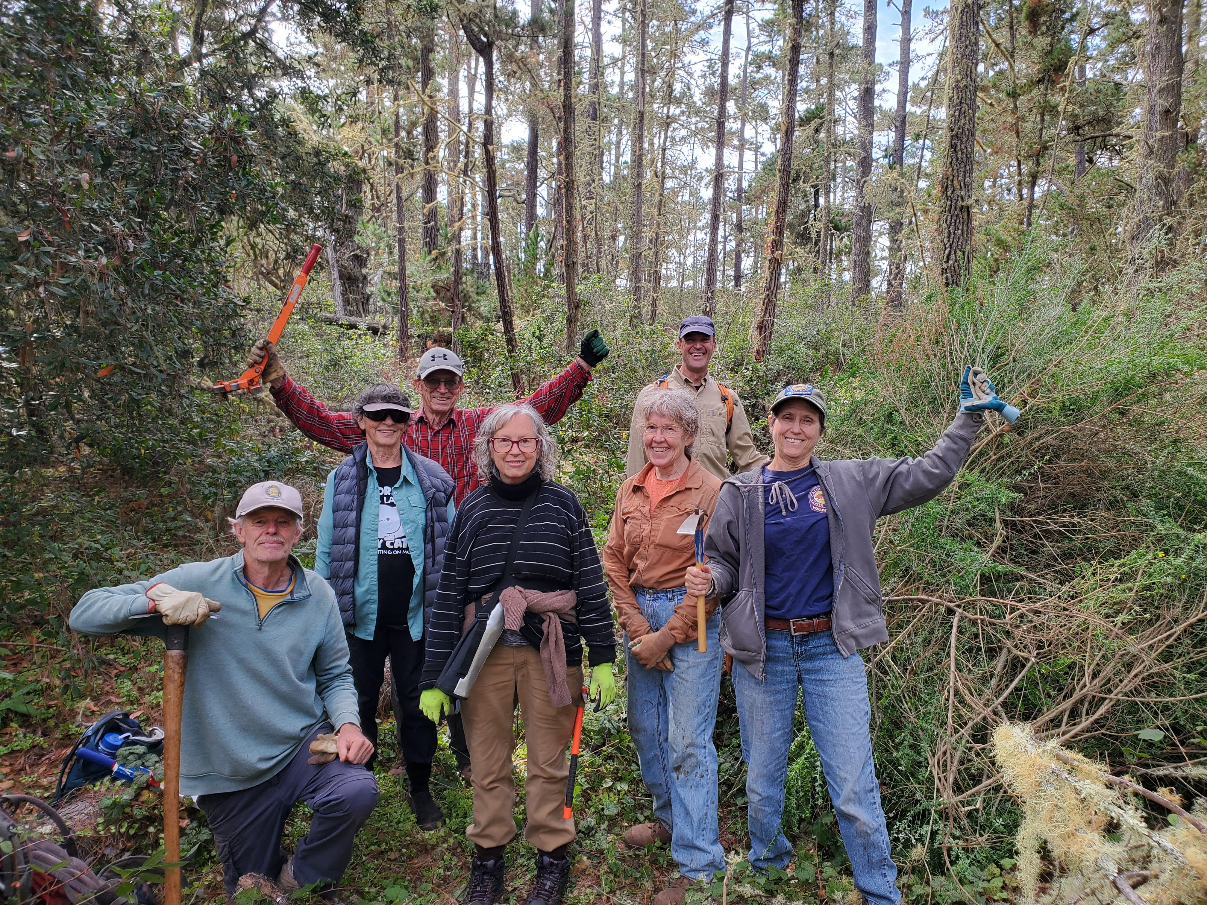 Volunteers pose triumphantly in the pine forest of Ishxenta State Park.